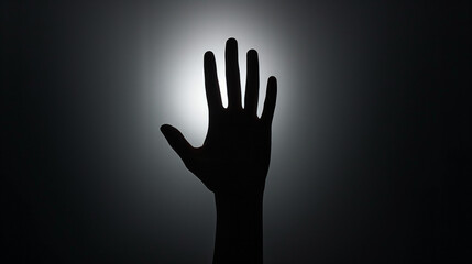Silhouette of an outstretched hand against a bright light, creating a dramatic and mysterious atmosphere