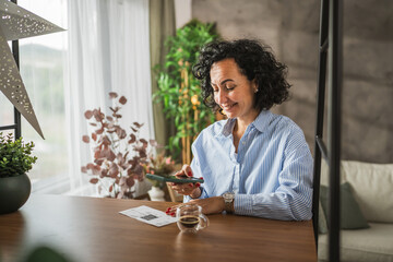 mature woman have contactleess payment on mobile phone at home