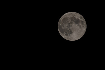 A high-resolution photograph of the full moon, capturing the intricate details of its surface against the dark night sky.