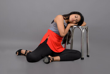 Indian female model in casual wear wearing red and grey designer top, black jeans and black high...
