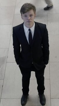 A Young Man Dressed in Formal Elegance Surrounded by a Busy and Crowded Urban Scene