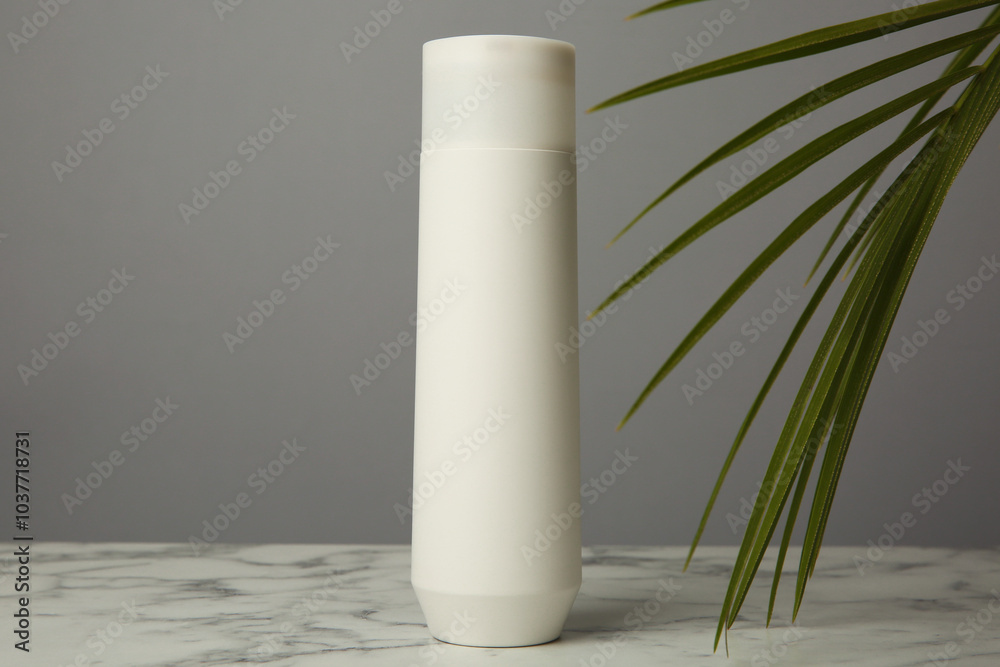 Sticker Bottle of shampoo on white marble table against grey background