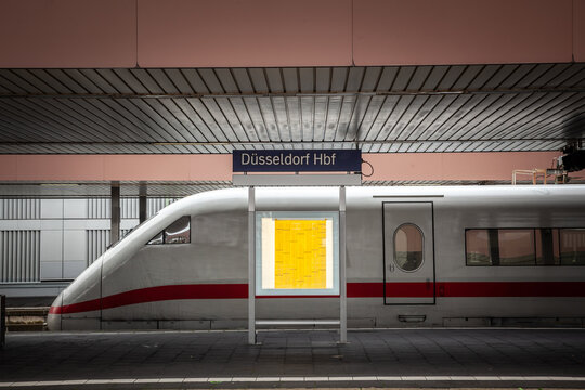 sign indicating Dusseldorf Hbf, or Dusseldorf Hauptbahnhof (Dusseldorf main train station in germany) the main railway hub of the german city with a german high speed train in background.