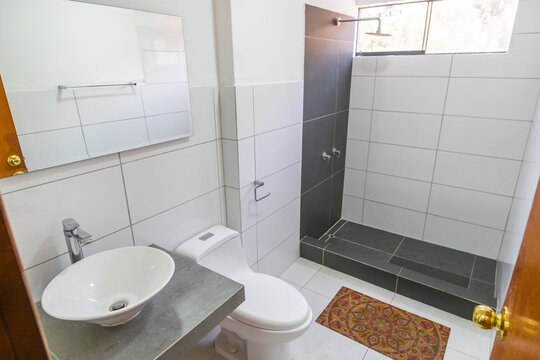 ba&ntilde;o de departamento con acabados de loza , lavabo inodoro y ducha con tina