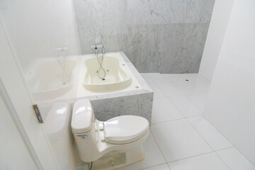 baño de departamento con acabados de loza , lavabo inodoro y ducha con tina