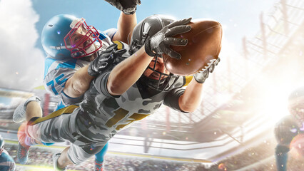 American football. Fighting for the ball in flight. Sport action. Fight. Sport emotion. Sports arena with fans. Bright
