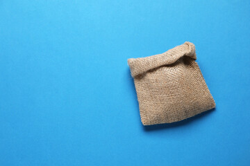 One burlap sack on light blue background, top view. Space for text