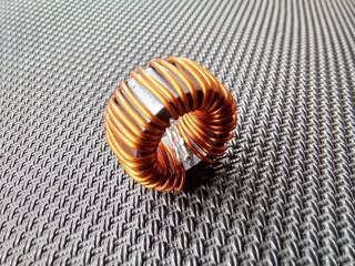 electronic components in the form of toroids or copper coils on circular ferrite with a textured...