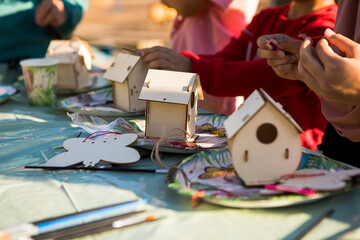 Fototapeta premium Kids hands making wooden toy house. hobby or leisure. DIY wooden house project.