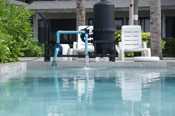 A mobile water filtration system is operating next to the swimming pool. Water filtration system releases treated water into the swimming pool.