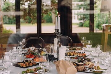 A beautifully arranged table is set with various plates of delicious food and elegant glasses filled with fine wine