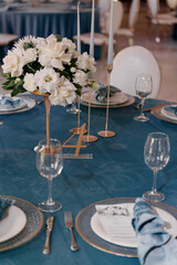 The elegant table is beautifully set up for a wedding reception, complete with exquisite plates, soft glowing candles, and vibrant flowers adorning it