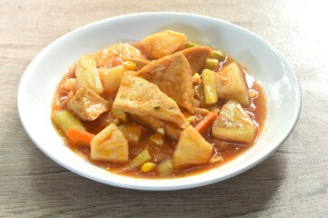 fried tofu with mixed vegetable in sweet and sour gravy sauce vegetarian food on plate 