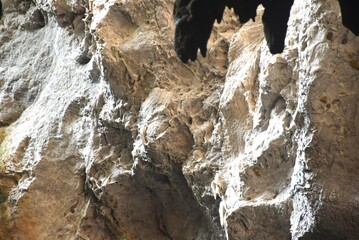 stalagmites and stalactites with sunlight through cave hole in Khao Luang cave travel location on Thailand
