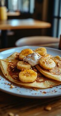 Close-up of a delicious stack of pancakes topped with sliced bananas, whipped cream, and a sprinkle of cinnamon.