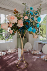 A beautifully arranged vase filled with various colorful flowers is thoughtfully placed on a wooden table, enhancing the rooms ambiance