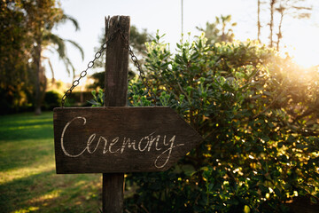A beautifully crafted wooden sign prominently displays the word ceremony elegantly engraved on it, capturing the essence of the occasion