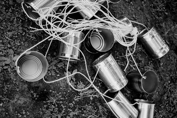 A striking black and white photo displays a fascinating pile of tin cans, uniquely connected to...
