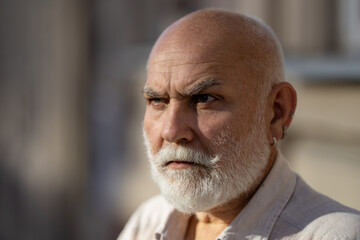 Middle-aged senior grandfather close up portrait. Grey hair white beard old man. Senior serious. Face of bearded senior age man. Closeup emotional portrait of an old mature senior man with grey beard.