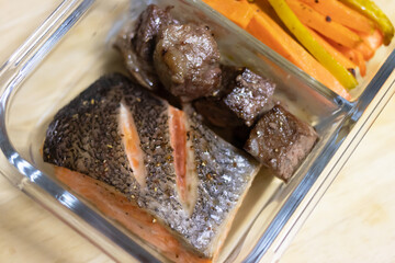 Healthy box salmon and beef steak with roasted carrots and potatoes sticks, healthy and easy meals.