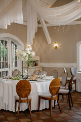 A welldecorated room featuring tables and chairs arranged specifically for a beautiful wedding reception event or celebration