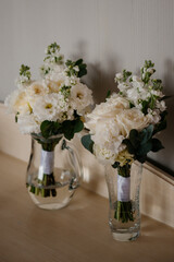 On a counter, there are two vases elegantly filled with beautiful white flowers, adding a touch of nature to the decor