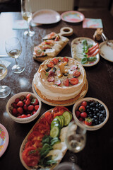 A beautifully arranged table adorned with an assortment of plates filled with delicious food items and a delightful cake on display