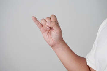 Male person hand shows pinky promise gesture, over grey