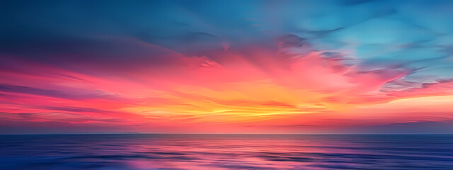 Vibrant sunset over the ocean, showcasing stunning hues of pink, orange, and blue across the sky and reflecting in the calm waters.