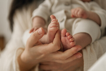 A woman is gently holding a newborn baby lovingly in her arms as she cradles the little one close...