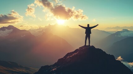 A man stands on a mountain peak, looking out at the horizon