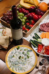 On the table, there is a beautifully arranged spread topped with an array of delicious plates of food and a bottle of fine wine