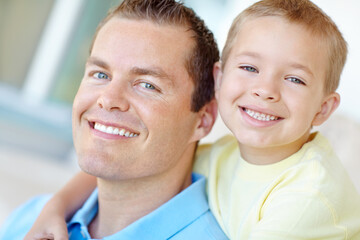 Fototapeta premium Boy, dad and happy with hug in home for portrait, bonding or love with support for connection in morning. Child, dad and man with smile for security, playful and piggy back at family house in France