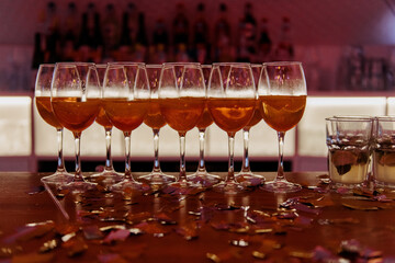 A beautifully arranged row of elegant wine glasses is meticulously lined up on a stylish table,...