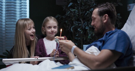At the hospital, young father receives a surprise birthday visit from woman and daughter.