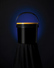 Paint bucket with yellow lid and blue light. Black technical plastic container. Empty black bucket. Front view. Place for label. Black background. Creative composition. © Artur