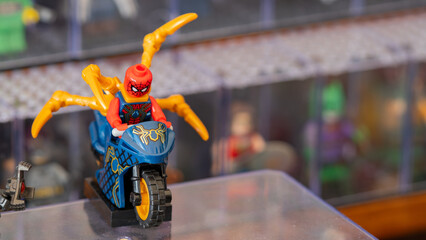 Obraz premium Budokan Geek Convention In GUAYAQUIL, ECUADOR - OCT 13, 2024 - Spider-Man action figure riding a motorcycle with golden spider legs at a toy display event.