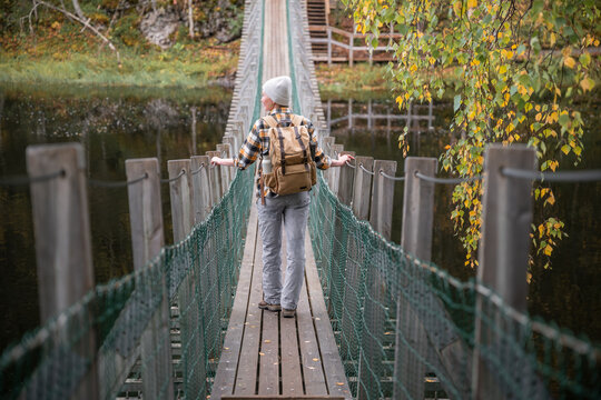 woman crossing a suspension bridge in Finland