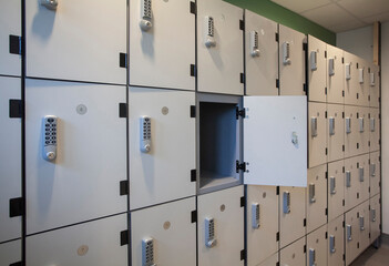 A wall of white lockers with keypads