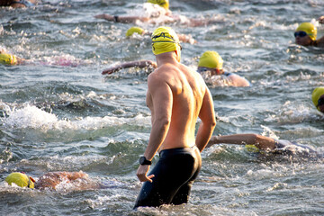 Triathlete swimming in open water, wearing a yellow swim cap