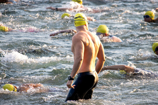 Triathlete swimming in open water, wearing a yellow swim cap