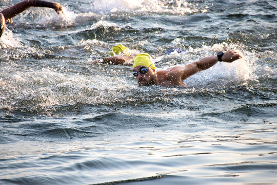 Triathlete swimming in open water, wearing a yellow swim cap