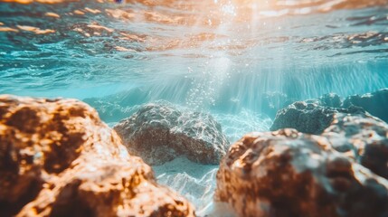 Underwater scene showcasing rocks and sunlight filtering through water.