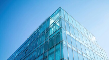 Exterior view of a modern glass office building against a clear blue sky