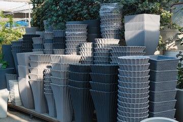 Fototapeta premium A neatly arranged display of contemporary garden planters in various shapes and sizes, featuring sleek designs at a garden supply store. Garden pots in various shapes and sizes for tree or flowers