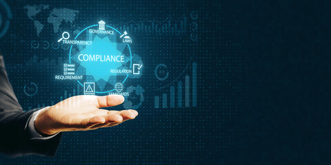 Businessman hand holding virtual compliance icons with digital governance and regulation data on dark background.