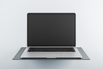 Front view on modern laptop blank black monitor with copyspace for your logo or text on dark stand isolated on light background. 3D rendering, mockup