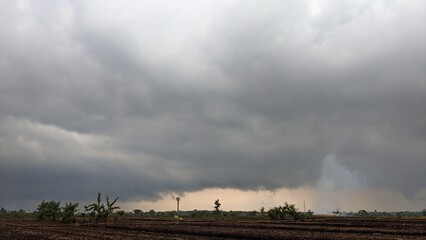 A dramatic sky with dark, ominous clouds. The clouds are thick and appear to be moving quickly. In...