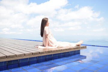 びわこテラスのウッドデッキに座るロングヘアののシニア女性