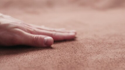 Slow motion man checking brown suede piece closeup